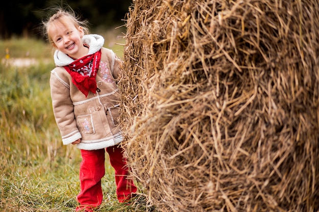 Una bambina allegra accanto a un pagliaio