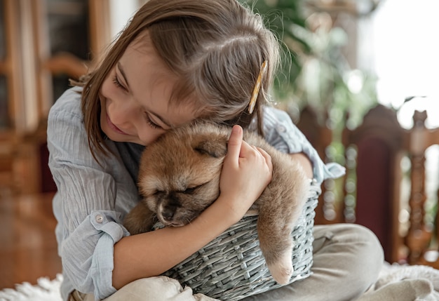 Una bambina ama e abbraccia il suo piccolo cucciolo.