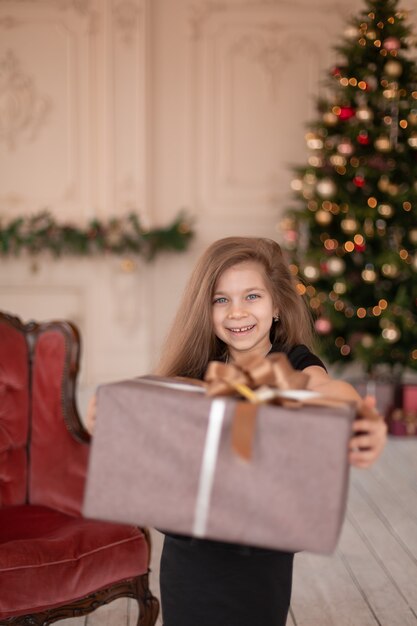 Una bambina apre un regalo di Natale da Babbo Natale. Racconto di Natale. Infanzia felice.