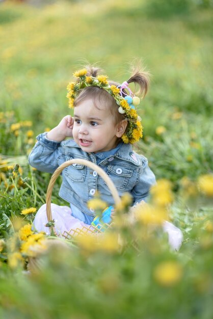 Una bambina carina con fiori di dente di leone in un campo estivo un bambino felice all'aria fresca