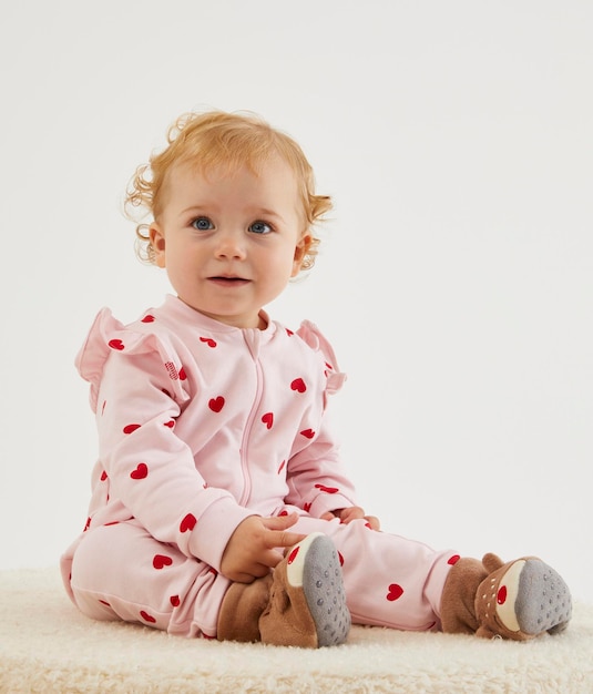 Una bambina carina con i capelli soffici e un viso sorridente .