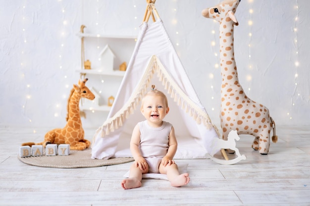 Una bambina carina è seduta in una sala giochi per bambini luminosa e accogliente Tessili per bambini per la scuola materna Un bambino felice