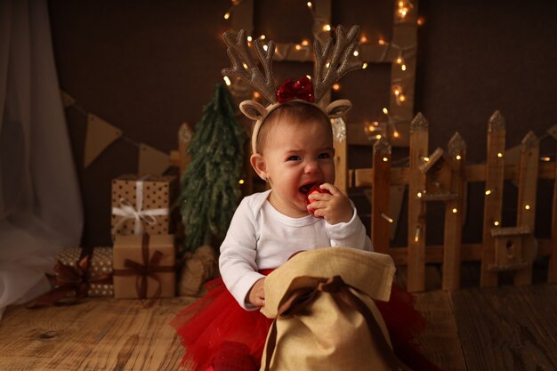 una bambina carina in costume di Capodanno tira fuori le palle di Natale da un sacchetto di regali