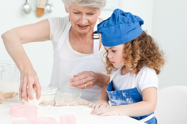 Una bambina che cuoce con sua nonna