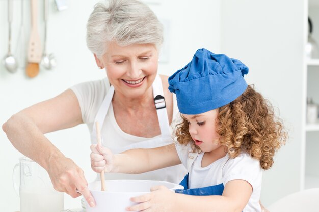 Una bambina che cuoce con sua nonna