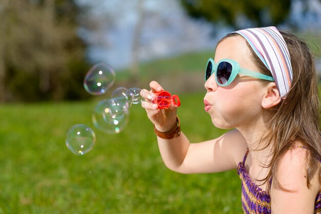 Una bambina che fa le bolle di sapone