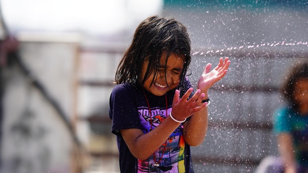 Una bambina che gioca con l'acqua con i suoi amici