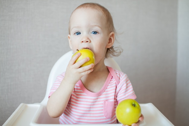 Una bambina che mangia mele fresche