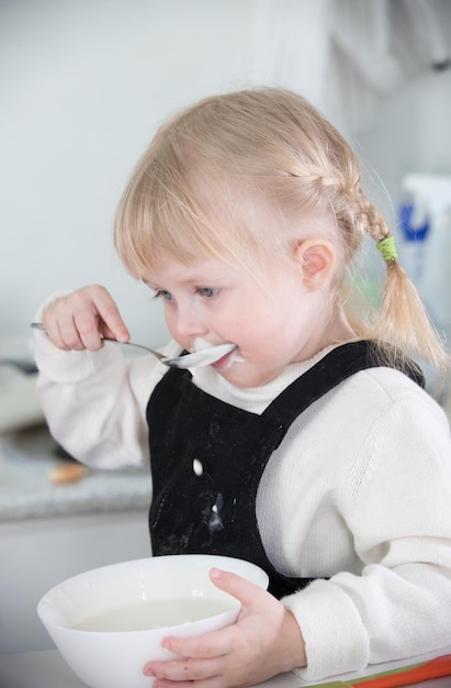 Una bambina che mangia una panna acida