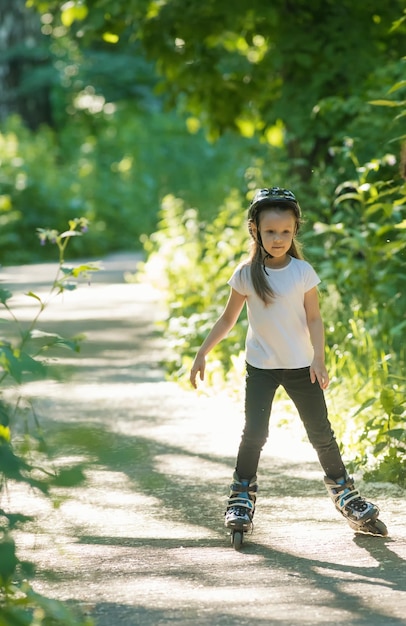 Una bambina che pattina nella foresta sui suoi rulli