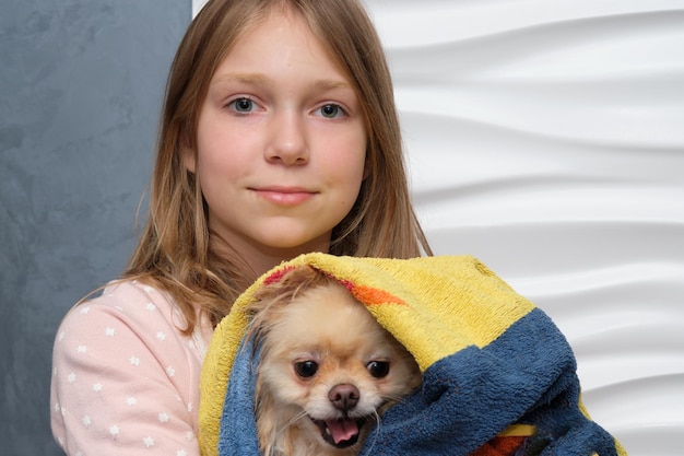 Una bambina con il suo amato cane in braccio Il concetto di sviluppare l'amore dei bambini per gli animali