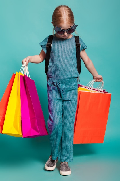 Una bambina con le borse colorate