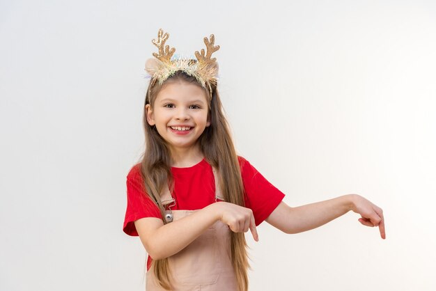 Una bambina con le corna di Natale indica l'annuncio.