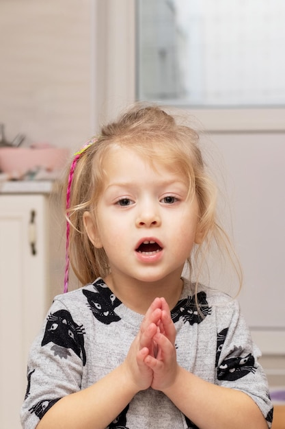 Una bambina con le mani giunte dice una preghiera