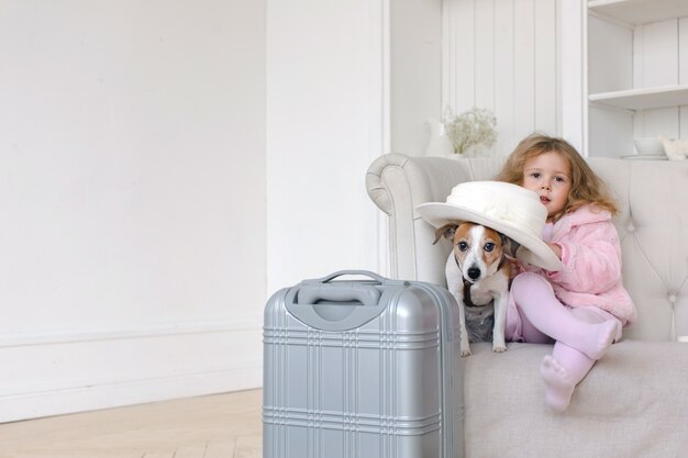 Una bambina con le valigie e un cane all&#39;interno