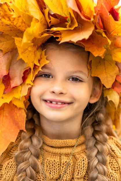 Una bambina con una corona di foglie d'acero in testa.