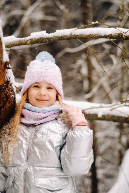 Una bambina con una giacca argentata d'inverno esce fuori d'inverno