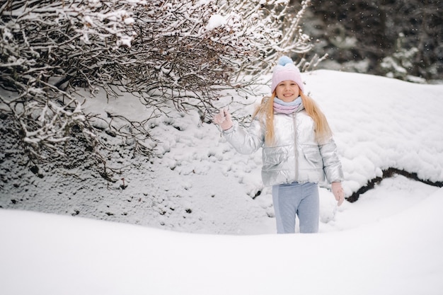 Una bambina con una giacca argentata d'inverno esce fuori d'inverno