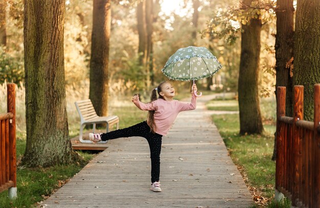 Una bambina corre con un ombrello in mano