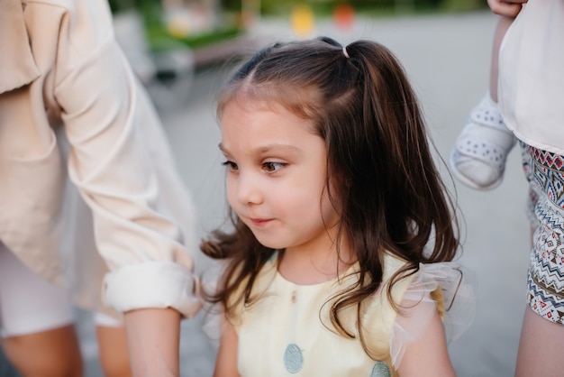 Una bambina corre e gioca nel parco in una giornata estiva durante il tramonto. Un'infanzia divertente e felice.