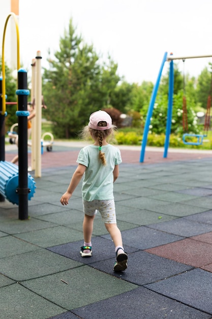 Una bambina di 4 anni lascia il parco giochi nell'inquadratura con le spalle Summer