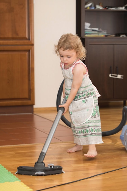 Una bambina di due anni sta pulendo l'appartamento. Avvicinamento