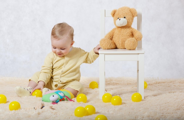 Una bambina di otto mesi vestita con un pigiama giallo gioca nella sua stanza