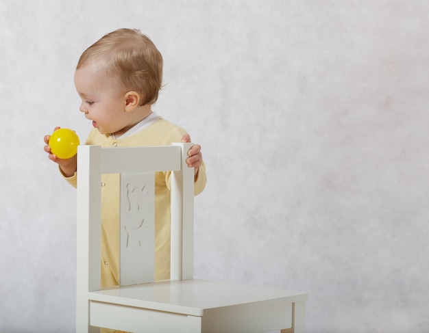 Una bambina di otto mesi vestita con un pigiama giallo gioca nella sua stanza