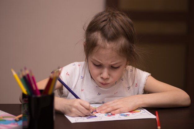 Una bambina disegna con le matite colorate