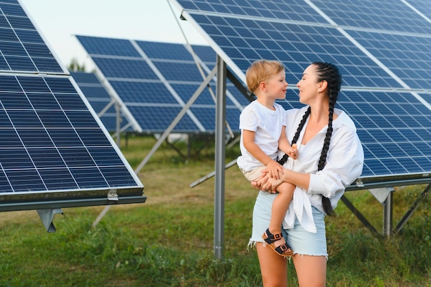 Una bambina e sua madre all'aria aperta accanto ai pannelli solari in una giornata di sole in una fattoria