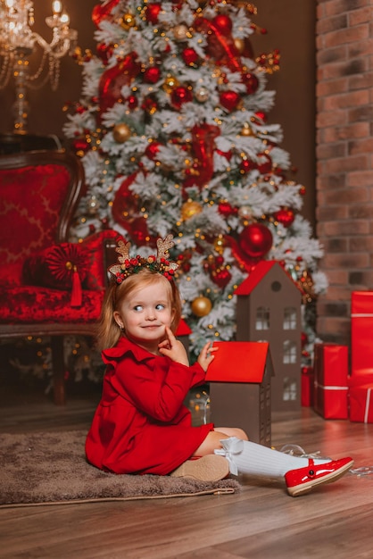 una bambina esprime un desiderio sotto un albero di Natale