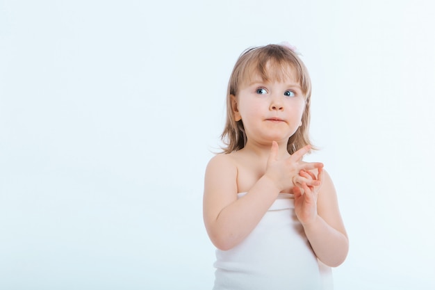 Una bambina fa una smorfia. Il bambino sta facendo qualcosa. Concetto di emozioni, espressioni facciali, infanzia, sincerità