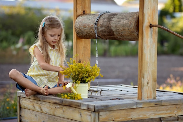 Una bambina ha raccolto dei fiori di campo e ne sta facendo un bouquet