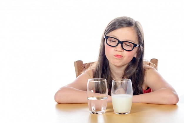 Una bambina ha una scelta tra acqua e latte