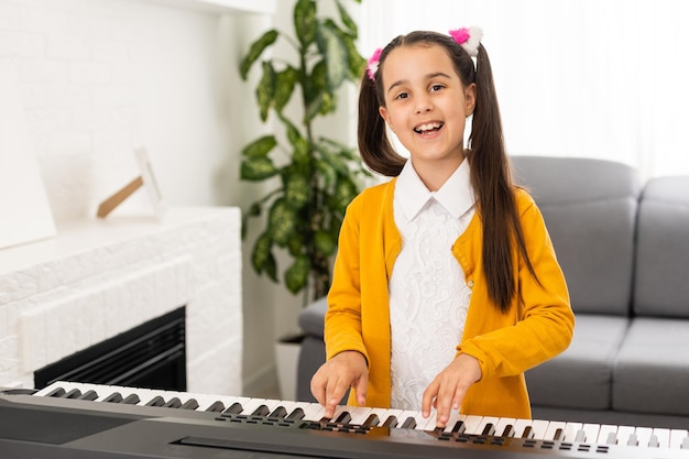 una bambina impara a suonare il sintetizzatore. imparare a suonare strumenti musicali.