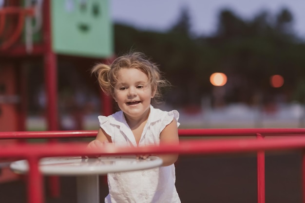 Una bambina in abiti estivi moderni che gioca nel parco in estate il fuoco selettivo