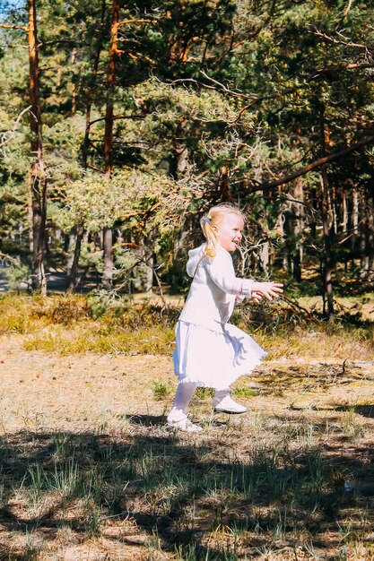 Una bambina in abito bianco che si diverte all'aperto