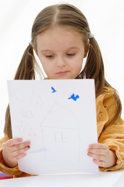 Una bambina in età prescolare sta guardando un disegno che ha disegnato