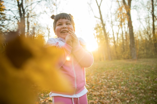 Una bambina in piedi nel parco autunnale