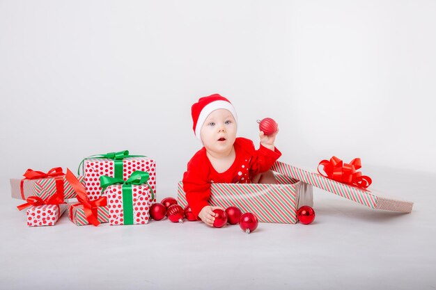 Una bambina in un costume da Babbo Natale con doni su uno sfondo bianco Babbo Natale Helper