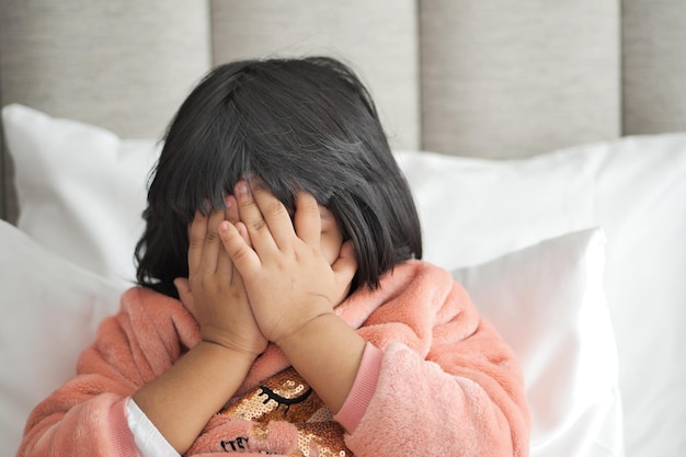 Una bambina sconvolta si copre il viso con la mano