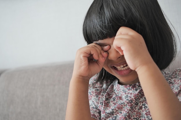 Una bambina sconvolta si copre il viso con la mano