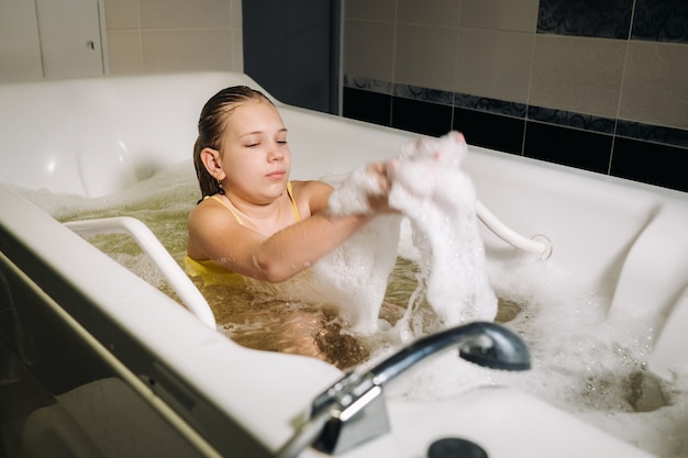 Una bambina segue la procedura in un bagno minerale. Il paziente riceve trattamenti in acqua con un bagno di perle minerali