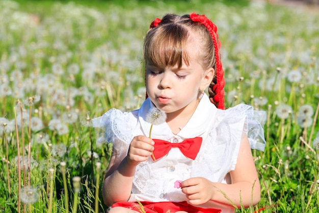 Una bambina si siede nella natura in estate con un panda giocattolo. Foto di alta qualità