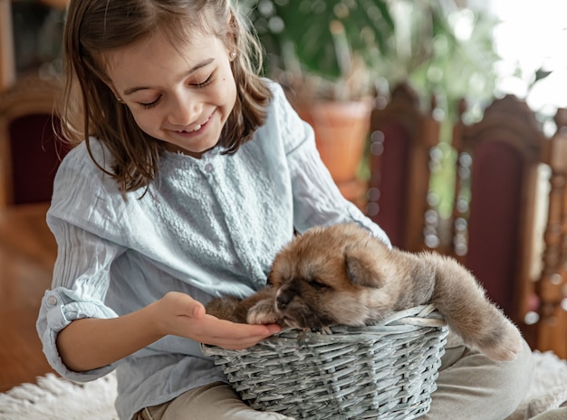 Una bambina sta giocando con il suo piccolo e soffice cucciolo