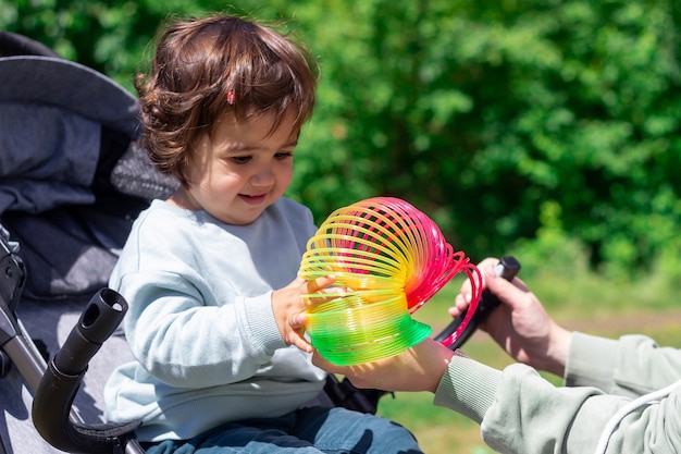 Una bambina sta giocando con un giocattolo arcobaleno elastico che sviluppa le capacità motorie