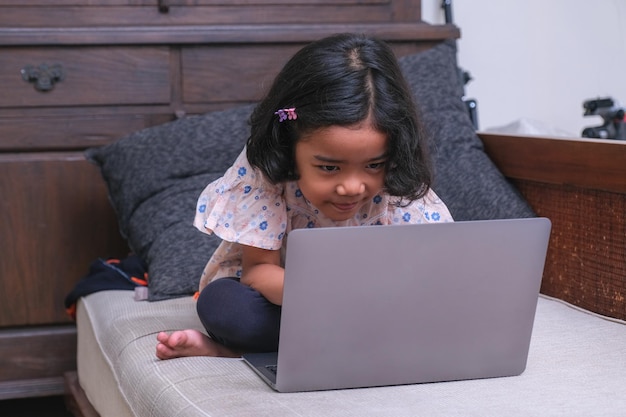 Una bambina sta guardando i cartoni animati su un computer portatile