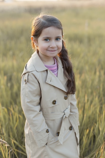 Una bambina sta in un campo Mani piegate Concetto di pace, speranza, sogni,