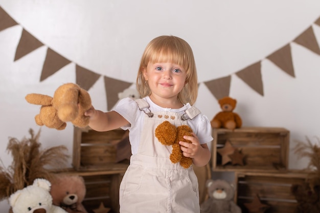 Una bambina tiene in mano un orsacchiotto.