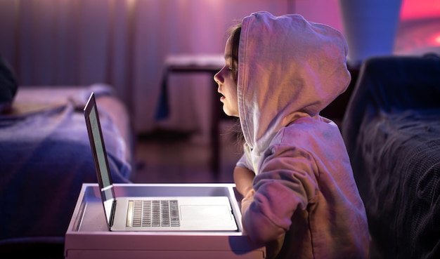 Una bambina usa un laptop a tarda notte